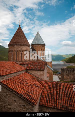 Mittelalterliche Steinkirchenkuppeln und rote Ziegeldächer mit Blick auf das malerische Zhinvali Reservoir Stockfoto