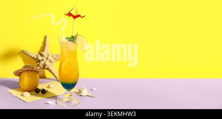 Glas leckerer Cocktail, Zitrone, Muscheln und Seesterne auf farbigem Hintergrund mit Platz für Text Stockfoto
