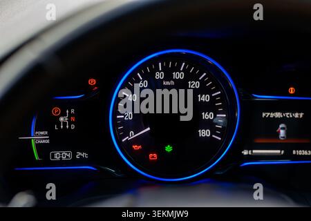 Digitaler Tachometer für Hybridfahrzeuge, Armaturenbrett und japanisches Warndisplay. Moderner Tachometer und Armaturenbrett aus nächster Nähe mit Illuminat Stockfoto