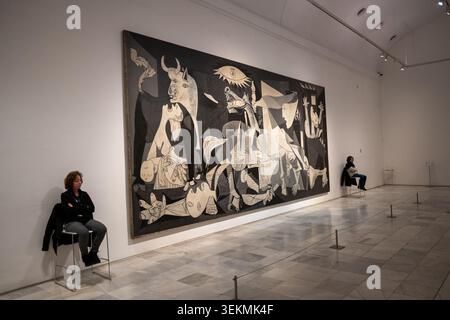 Großer Blick auf Pablo Picassos Guernica-Wandbild in einer großen Galerie mit Besuchern, fotografiert im Reina Sofia Museum in Madrid, Spanien. Stockfoto
