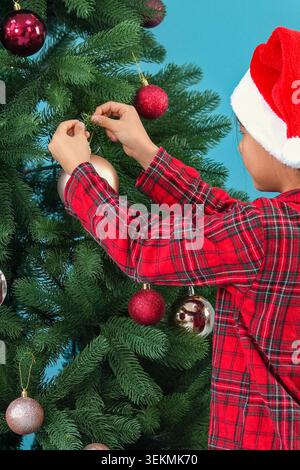 Glückliche Person, die festliche Ornamente und glitzernde Dekorationen auf einer Tradition arrangiert Stockfoto