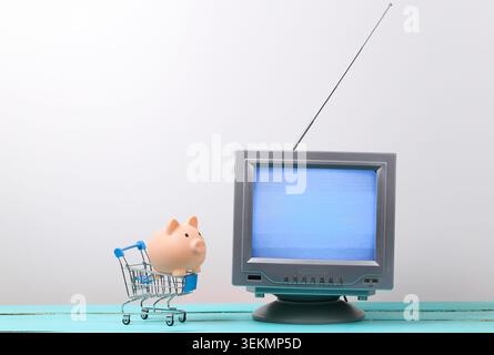 TV-Shop. Antenne altmodischer Retro-fernseher und Mini-Supermarkt-Trolley mit Schweinebank auf weißem Hintergrund Stockfoto