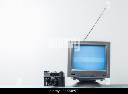 Antenne altmodischer Retro-tv-Receiver und Filmkamera auf weißem Wandhintergrund Stockfoto