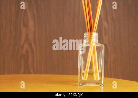 Minimalistischer Schilfdiffusor mit Aromaöl in einer Glasflasche auf einem Holztisch. Entspannender Duft und Aromatherapie-Konzept mit Kopierraum Stockfoto