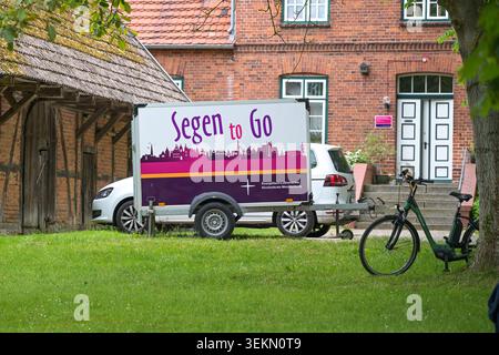 Schlagsdorf, Deutschland, 31. Mai 2026: Wohnwagen mit der Aufschrift Segen to go (bedeutet Segen to go) Parken vor einem alten Pfarrhaus, religiös in Stockfoto