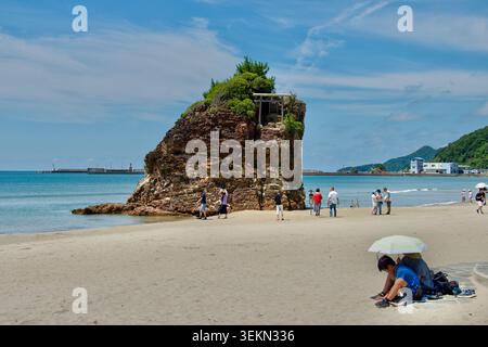 Besucher werfen einen Blick auf die mit einem Schrein bedeckte Insel am Inasa Beach in Izumo, Präfektur Shimane, Japan. Stockfoto