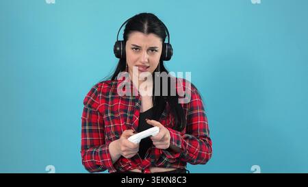 Authentisches emotionales Porträt mit fokussierter junger Frau, die Kopfhörer trägt p Stockfoto