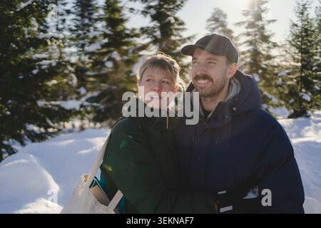 Glückliches Paar, das Freizeit im Winterwald verbringt Stockfoto