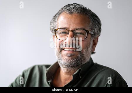 Kopffoto-Porträt eines lächelnden reifen Geschäftsmannes mit Brille Stockfoto
