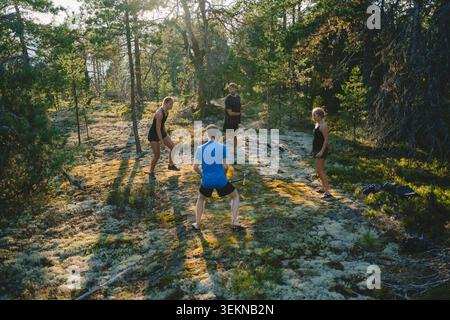 Hochwinkelansicht von Freunden, die Spikeball im Wald spielen Stockfoto