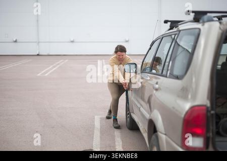 Die volle Länge des weiblichen Radschraubers beim Reifenwechsel des Autos Stockfoto