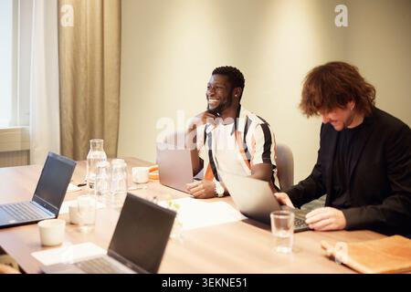 Verschiedene Geschäftspartner diskutieren während sie im Besprechungsraum im Büro sitzen Stockfoto