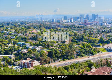 Der erhöhte Blick zeigt die üppigen grünen Viertel von West Los Angeles, die zur Skyline von Century City und den weit entfernten Wolkenkratzern der Innenstadt unter A führen Stockfoto