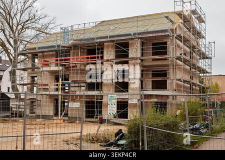 Ein mehrstöckiges Wohngebäude im Bau mit Betonwänden, umfangreichen Stahlgerüsten und einem Dachrahmen an einem bewölkten Tag. Stockfoto