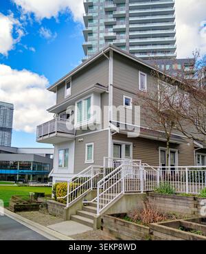 Modernes Wohnhaus und urbaner Hochhaushintergrund an einem sonnigen Tag Stockfoto