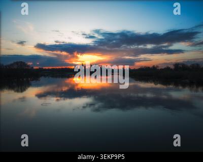 Luftaufnahme der Skyline von Warschau bei Sonnenuntergang mit dramatischen Wolken, die sich auf der ruhigen Oberfläche der Weichsel in Warschau, Woiwodschaft Masowien, spiegeln. Stockfoto