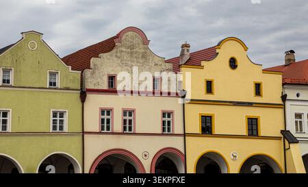 Traditionelle europäische Architektur mit lebhaften Fassaden und Bogengängen unter bewölktem Himmel Stockfoto