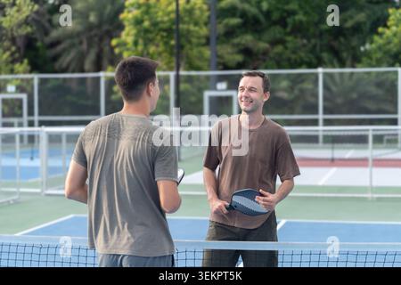 Aktive, vielfältige Leute spielen Pickleball auf dem Outdoor Court Stockfoto
