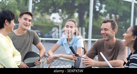 Aktive, vielfältige Leute spielen Pickleball auf dem Outdoor Court Stockfoto