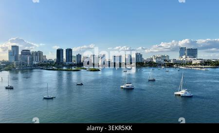 Aus der Vogelperspektive auf die Skyline der Stadt und die vor Anker liegenden Segelboote im ruhigen blauen Wasser unter klarem Himmel in Palm Beach, Florida, USA. Stockfoto