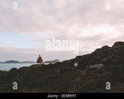 Der berühmte leuchtend rote Punta Robaleira Leuchtturm auf den zerklüfteten Felswänden von Costa da Vela, Cangas, Galicien, Spanien. Atlantik Stockfoto