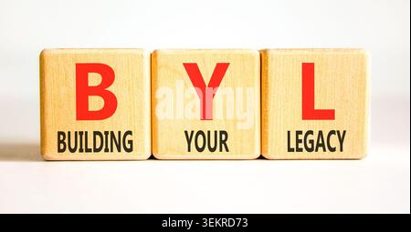 BYL baut Ihr altes Symbol auf. Concept Words BYL baut Ihr Vermächtnis auf wunderschönen Holzblöcken auf. Schöner weißer Hintergrund. Business BYL Gebäude Stockfoto