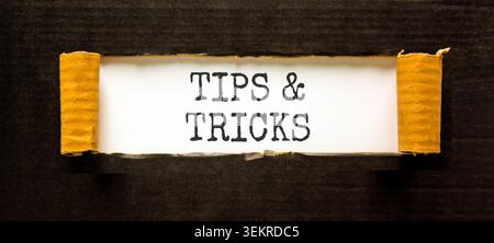 Symbol für Tipps und Tricks. Konzeptwörter Tipps und Tricks auf wunderschönem Whitepaper. Schöner schwarzer Hintergrund. Geschäftliche Tipps und Tricks Motivationa Stockfoto