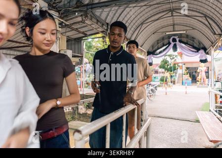 Junge Menschen, die in der Schlange stehen, auf überdachten Wegen, in der urbanen Szene Stockfoto