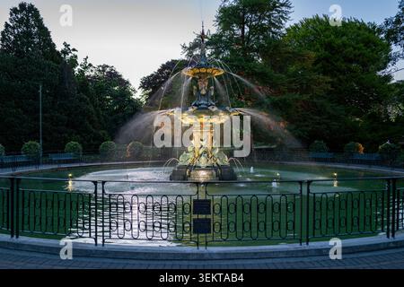 Der historische Peacock Fountain beleuchtet in der Dämmerung in Christchurch, Neuseeland. 1911 von der Coalbrookdale Foundry geschaffen, mit Restaurierungsdeta Stockfoto
