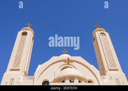 Koptische christliche Kirche mit zwei Glockentürmen und verzierten Kreuzen in Scharm El Sheikh Ägypten, von unten gesehen, vor einem tiefblauen Himmel, der die Religionen zeigt Stockfoto