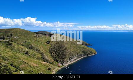 Drohnenansicht auf die Halbinsel Isla del Sol, den Titicacasee, Bolivien. Grüne Terrassenhügel und blaues Wasser. Stockfoto