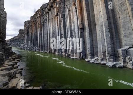 Türkisfarbener Fluss, der durch sechseckige Basaltsäulen im Stuðlagil Canyon im Jökuldalur Valley in Island fließt Stockfoto
