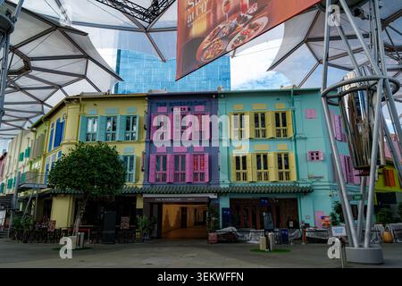 SINGAPUR - 29. JUNI 2025: Traditionelle farbenfrohe Shophouses mit pastellfarbenen Fensterläden unter dem modernen Baldachin im Clarke Quay River District Stockfoto