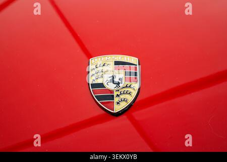Luzern, Schweiz, 30. Mai 2026. Eine zentrierte Nahaufnahme fängt das aufwändige Gold-, Schwarz- und rote Porsche-Wappen-Emblem ein, das auf einer Brigde angebracht ist Stockfoto
