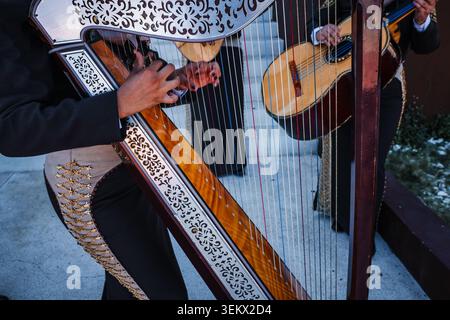 Nahaufnahme eines Musikers, der eine traditionelle mexikanische Mariachi-Harfe spielt. Volksmusik mit Streichinstrumenten und Musikern in charro-Anzug Stockfoto