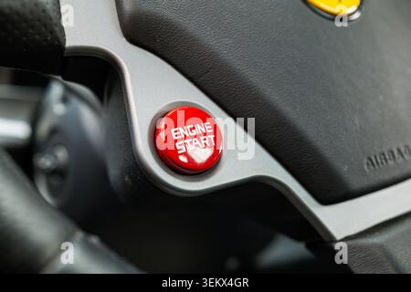 Luzern, Schweiz, 30. Mai 2026. Die detaillierte Aufnahme konzentriert sich auf den leuchtend roten Zündknopf mit weißem Schriftzug, der in das Aluminium- und schwarze lea-Design eingelassen ist Stockfoto