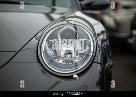 Luzern, Schweiz, 30. Mai 2026. Die Close-up-Makroaufnahme erfasst die internen Reflektorgeometrien und das Glühlampendesign innerhalb des charakteristischen ovalen Scheinwerfers Stockfoto