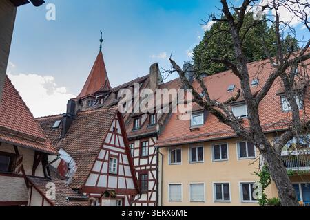 Traditionelle Fachwerkhäuser und rot gekachelte Dächer unter einem historischen Turm in Nürnberg, Bayern, Deutschland am Sommertag. Stockfoto