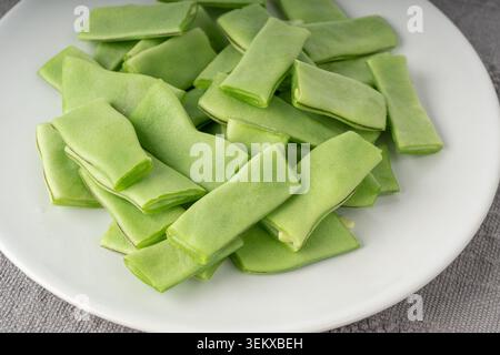 Phaseolus coccineus flache grüne geschnittene Schoten Textur aus nächster Nähe. Scharlachrote Bohnenschnitte oder mehrflorale Bohnenschoten Makromuster Stockfoto