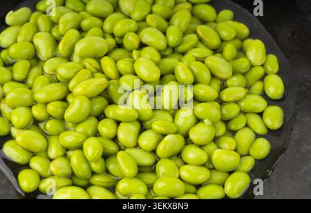 Edamame Bohnen Schüssel strukturierter Hintergrund. Grüne Sojabohnen, viele gekochte junge Sojabohnen, gekochte japanische Erbsen aus nächster Nähe Stockfoto
