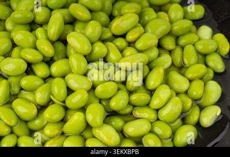 Edamame Bohnen Schüssel strukturierter Hintergrund. Grüne Sojabohnen, viele gekochte junge Sojabohnen, gekochte japanische Erbsen aus nächster Nähe Stockfoto