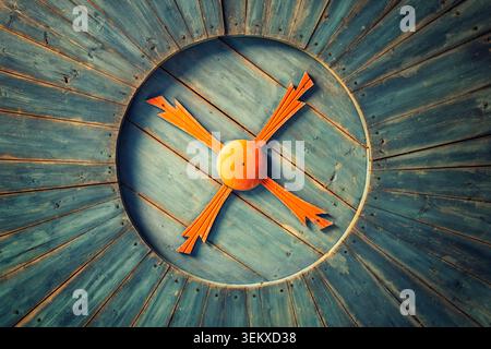 Petäjävesi, Finnland - 04.07.2021: Nahaufnahme aus rustikal blau lackiertem Holz mit einem orangen X-förmigen Ornament auf einer runden, vertieften Platte Stockfoto