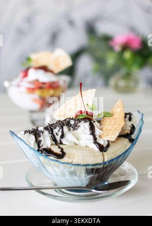 Bananeneis Eisbecher Dessert auf weißem Tisch im Gartencafé im Freien Stockfoto