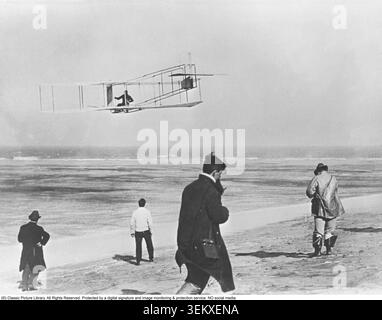 Wilbur und Orville Wright, geboren in Dayton, Ohio (Wilbur 1867–1912, Orville 1871–1948), waren die amerikanischen Brüder, die die Welt durch die Entwicklung des ersten motorisierten und kontrollierten Flugzeugs veränderten. Nach jahrelangem Experimentieren mit Segelflugzeugen und mechanischen Systemen erreichten sie den ersten Flug in der Geschichte am 17. Dezember 1903 in Kitty Hawk, North Carolina. Das Foto zeigt Orville Wright während einer Flugübung mit einem nicht motorisierten Segelflugzeug im Jahr 1911. Die Arbeit der Brüder Wright legte den Grundstein für die moderne Luftfahrt, und ihre Kombination aus Ingenieurskunst, Mut und Entschlossenheit machte sie aus Stockfoto