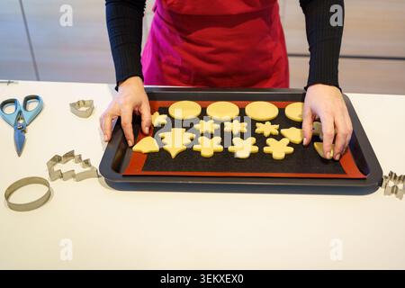 Baker, der rohe Teigkekse auf einem Backblech anlegt, bereit für den Ofen Stockfoto