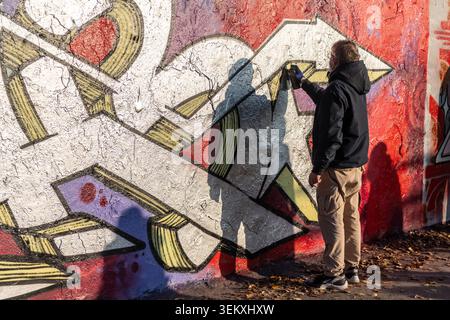 Berlin, Deutschland - 13. November 2022. Eindruck von Straßenkünstlern, die Reste der historischen Berliner Mauer im Mauerpark neu malen Stockfoto