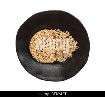 Broken Rohnudeln isoliert, trockene runde Ramen-Nudeln, ungekochte zerbröckelte Korea Vermicelli, schnelle chinesische Weizennudeln, Instant Macaroni auf schwarzer Platte, Wh Stockfoto