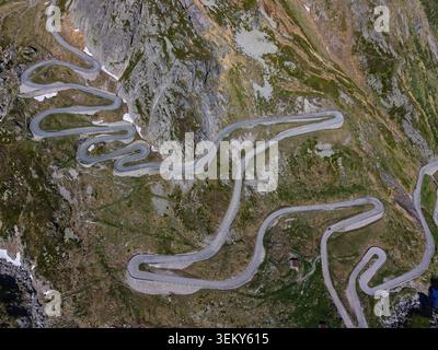 Aus der Vogelperspektive auf die kurvenreiche Tremola-Straße und ihre berühmten Haarnadelkurven am Gotthard-Pass in Airolo, Tessin, Schweiz. Stockfoto
