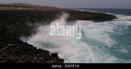 Raue Kalksteinfelsen an der Nordküste Curacaos, wo mächtige karibische Wellen gegen felsige Klippen und natürliche Meeresformationen krachen. Stockfoto