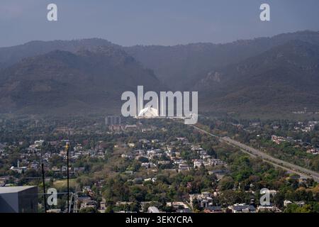 Blick aus der Vogelperspektive auf die Faisal Moschee am Fuße der Margalla Hills mit der städtischen Landschaft und dem üppigen Grün von Islamabad, Islamabad Capital Territor Stockfoto